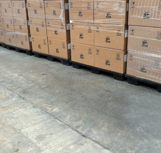 Stacked cardboard boxes on pallets in a warehouse setting.
